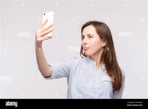 Young Woman Making Selfie With Smartphonefunny Face And Sticking Tongue At Camera While Making