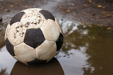 Dirty Soccer Ball In Muddy Puddle Space For Text Stock Photo Image