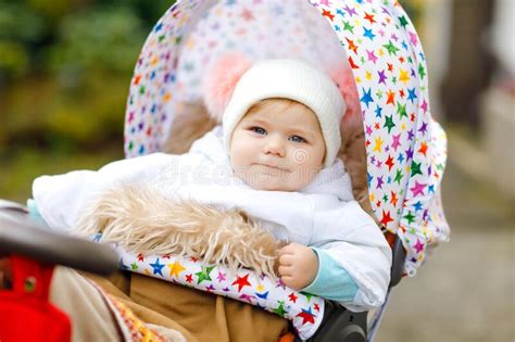 Cute Little Beautiful Baby Girl Sitting In The Pram Or Stroller On