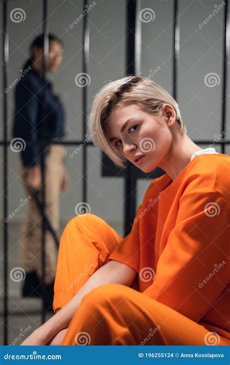 Blonde Inmate In An Asian Women`s General Security Prison Is Led Out Of Her Cell By A Uniformed