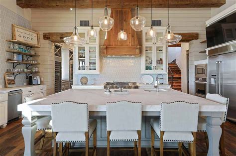 A Large Kitchen With White Cabinets And Wooden Floors Is Pictured In