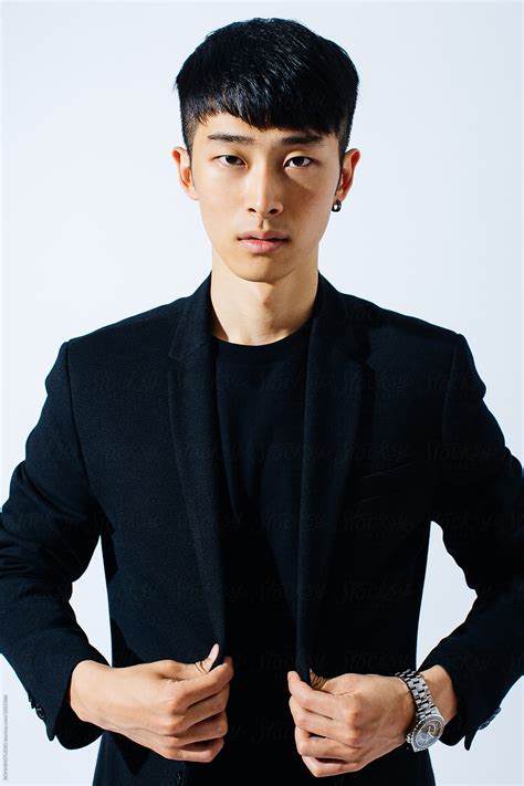 Portrait Of An Attractive Asian Man Wearing A Black Suit By Stocksy