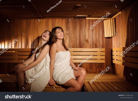 Close Up Photo Of Two Beautiful Women Wearing White Towels In A Wooden