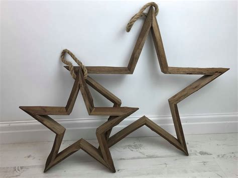 A Contemporary Set Of Chunky Solid Wooden Stars Hanging Via A Natural