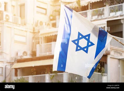 Israeli Flag With Star Of David In Front Of Windows Of A Residental