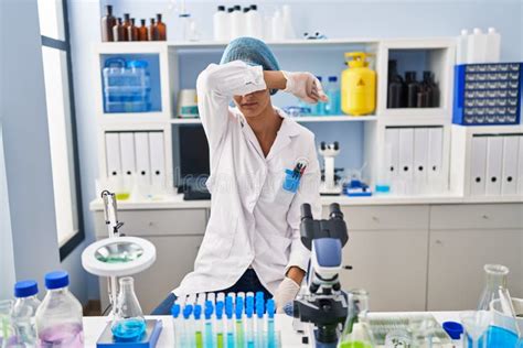 Brunette Woman Working At Scientist Laboratory Covering Eyes With Arm