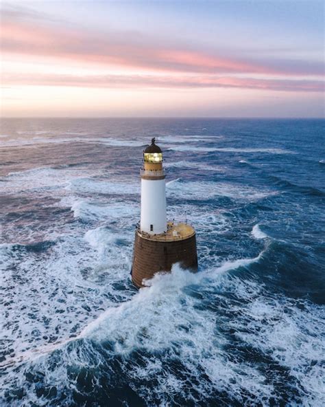 Premium Photo Waves Hitting A Lighthouse In Scotland