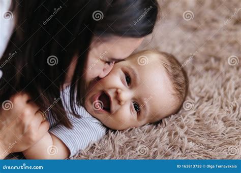 glad trevlig familj mor och barn kysser skrattar och kramar hemlycka arkivfoto bild av flicka