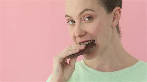 Woman Eating Chocolate Over Pink Background Stock Footage Videohive