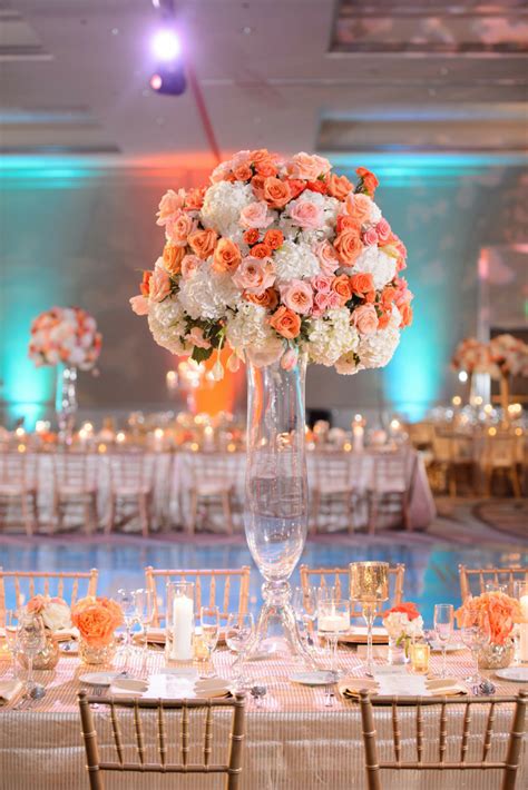 Bright Tall Wedding Centerpiece Designed With Orange And Pink Roses And