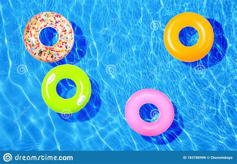 Different Inflatable Rings Floating In Swimming Pool Stock Photo