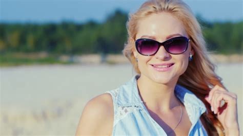 Sexy Blonde Woman In Sunglasses Posing For The Camera At The Beach Stock Footage