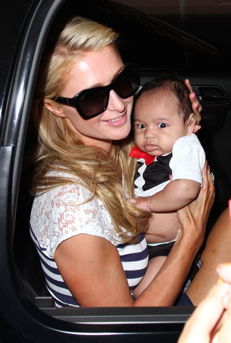 Dlisted Paris Hilton Poses With A Baby While Arriving At Lax From Korea