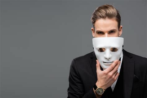 Businessman Holding Mask Near Face While Looking At Camera Isolated On