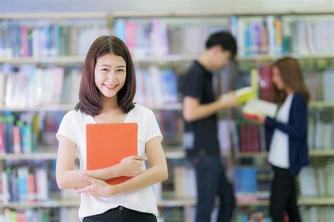 Asian Student Lady Smile And Read A Book In Library In University With