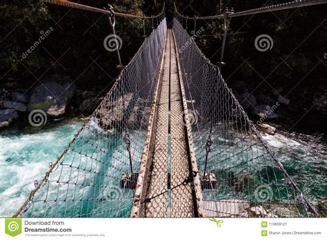 Suspension Bridge Over A Beautiful Turquoise River On The Hollyford