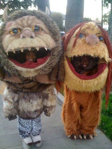 Two People In Costumes Walking Down A Sidewalk