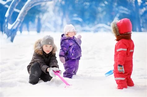 Premium Photo Little Children In Winter Clothes Having Fun In Park At