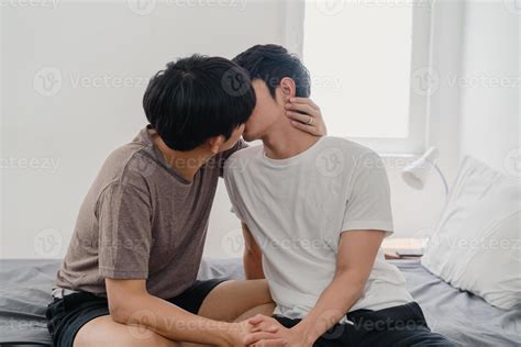 pareja gay asiática besándose en la cama en casa jóvenes asiáticos lgbtq hombres felices