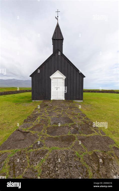 Traditional Black Church With White Wooden Door In Barren Landscape
