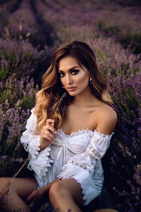 Beautiful Girl With Blond Hair In Elegant Clothes Posing In Summer Flowering Lavender Field