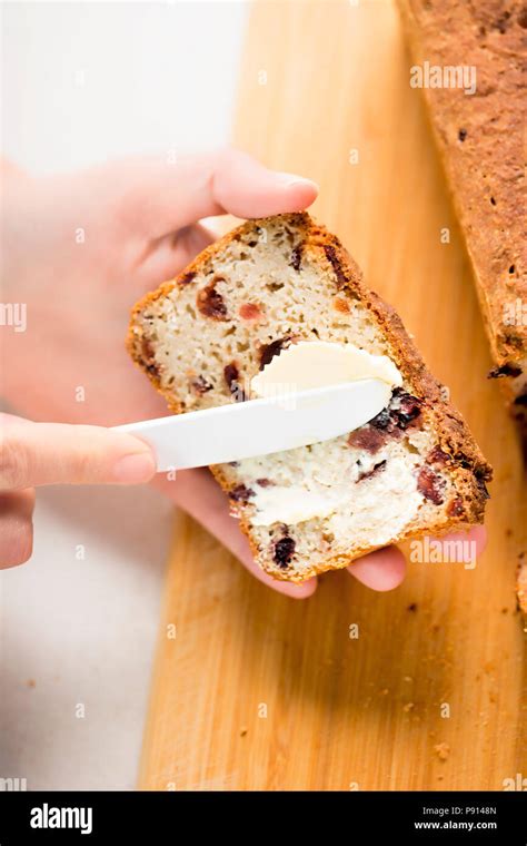 Woman Spreading Butter On Slice Of Sweet Cranberry Bread Stock Photo Alamy