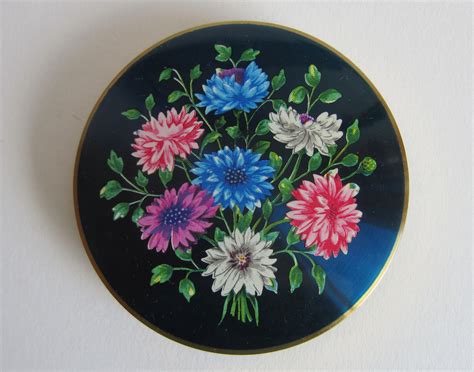A Blue Plate With Colorful Flowers Painted On The Front And Sides