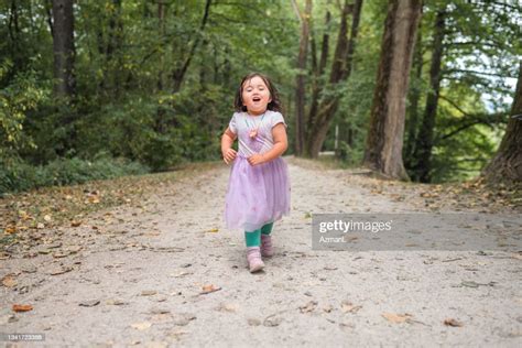 Kleines Mädchen Das Auf Dem Fußweg Neben Einem See In Einem Öffentlichen Park Rennt Stock Foto