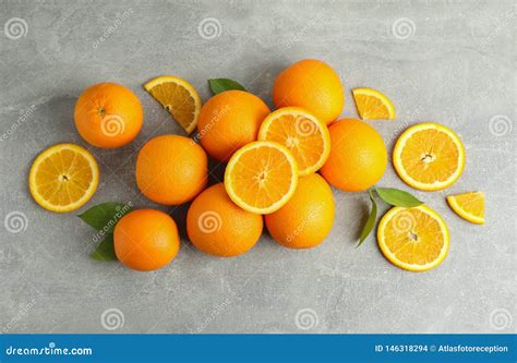 Many Ripe Oranges And Leaves With Space For Text On Grey Table Stock