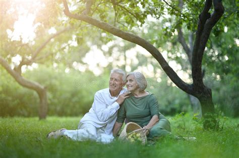 Senior Couple Sitting On The Grass In The Park Stock Photo Image Of