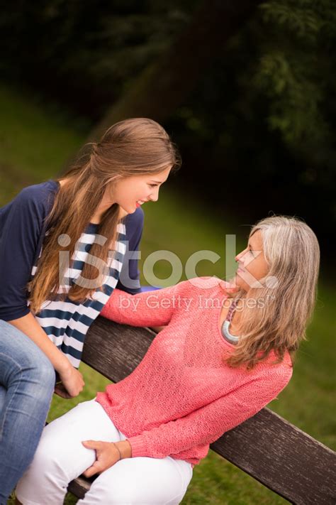 Mother And Daughter Have Conversation On Park Bench Stock Photos