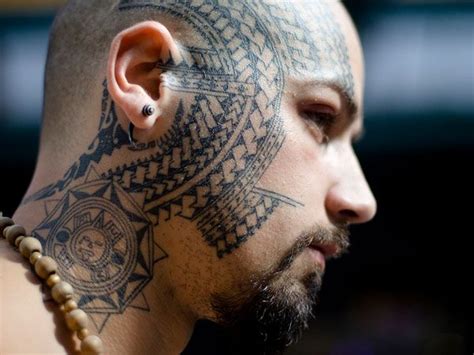 A Man With Tattoos On His Face And Neck