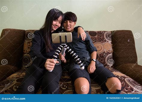 giovane coppia lesbica asiatica seduta sul divano insieme e a l immagine stock immagine di