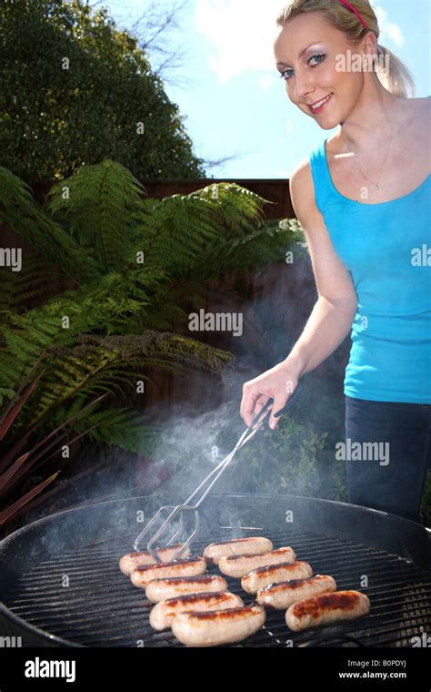 Young Woman Cooking Sausages Model Released Stock Photo Alamy