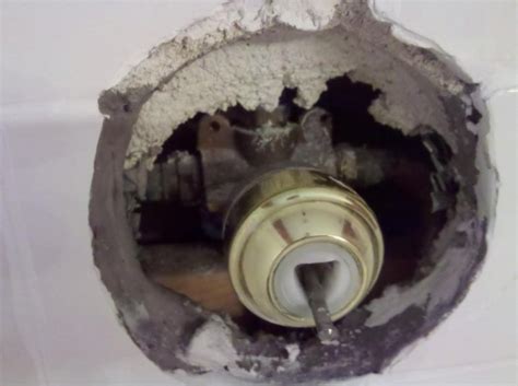Look at the center of the trim plate behind the shower handle to find a brand name or manufacturer symbol. Shower faucet identification