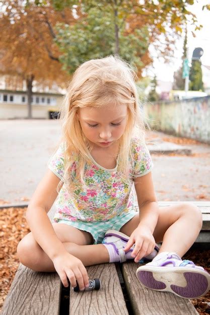 Premium Photo Child Girl Blonde Preschool Age Sits On A Bench