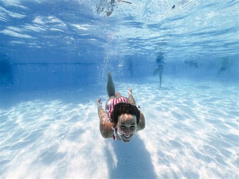 Happy Woman Swimming Underwater In Pool At Tourist Resort Stock Photo