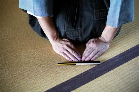 High Angle Close Up Of Japanese Man Kneeling On Tatami Mat In Front Of