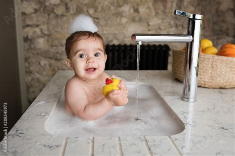 Baby Taking Bubble Bath In Kitchen Sink Holding Rubber Duck Buy This
