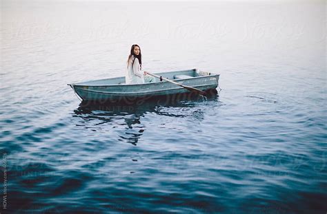 Lonely Girl Floats Alone In A Row Boat On A Foggy New England Morning By Howl Stocksy United