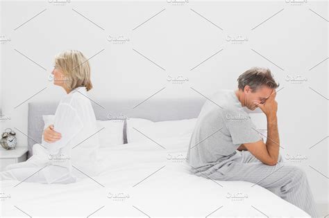 Couple Sitting On Opposite Sides Of Bed High Quality Stock Photos