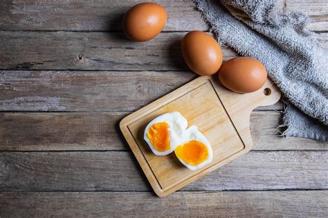 Huevos Cocidos Y Huevos Crudos En Una Mesa De Madera Foto Premium