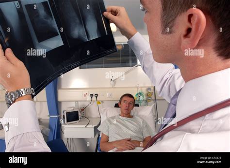 A Doctor On His Hospital Ward Round Examines A Patients X Ray Stock