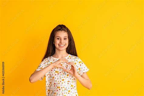 Foto Stock Portrait Of A Happy Cute Young Girl Making A Heartfelt