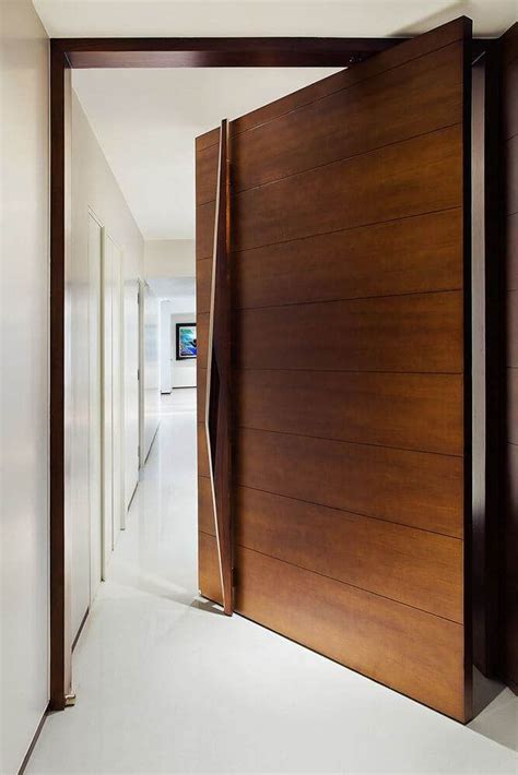 An Open Wooden Door Leading Into A Hallway With White Walls And