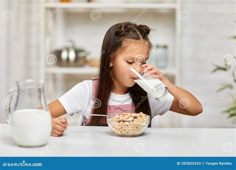 Cute Little Girl Eating Breakfast Cereal With The Milk Stock Image