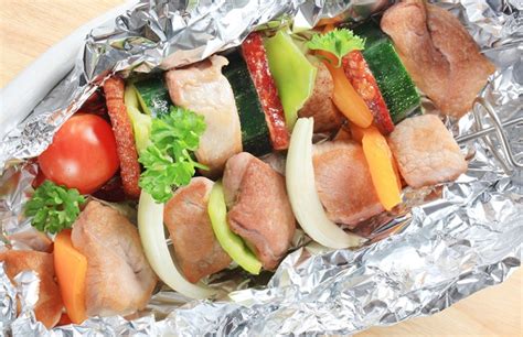 Carne, papas y vegetales en platos de aluminio. Cocinar alimentos con papel aluminio afecta la salud