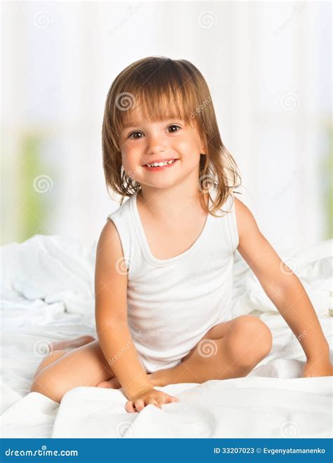 little happy smiling cheerful girl in a bed stock image image of cute girl 33207023