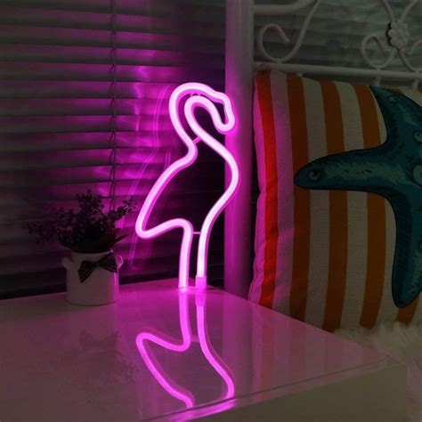 A Pink Flamingo Neon Sign Sitting On Top Of A Table