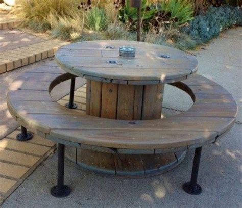 An Outdoor Table Made Out Of Two Wooden Barrels And Some Metal Legs On